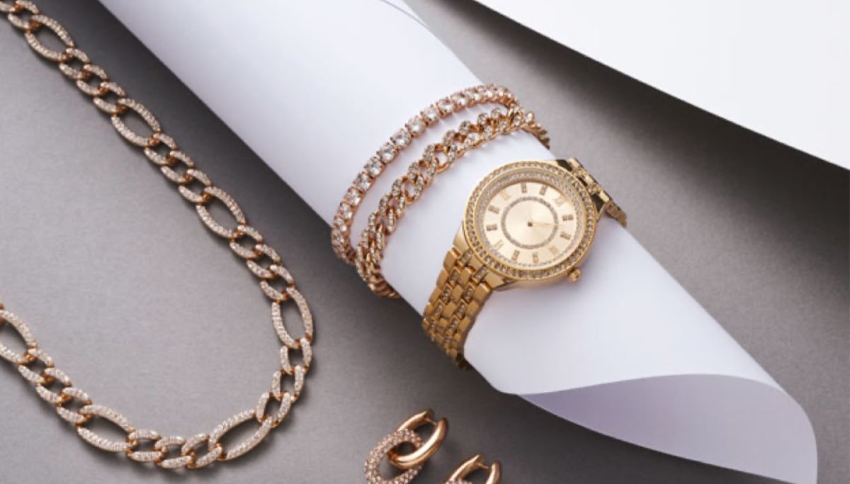 Goldschmuck wie Armbänder, Uhren und Kette auf grauem Untergrund. Bijou Brigitte nutzt tamigo zur Steigerung der betrieblichen Effizienz.