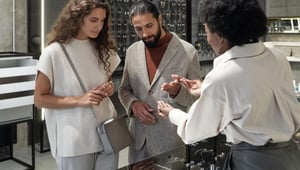 Conseiller en vente au détail de produits de luxe servant les clients dans une boutique