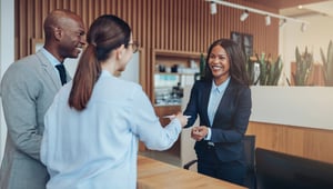 Female receptionist at a hotel desk greeting guests