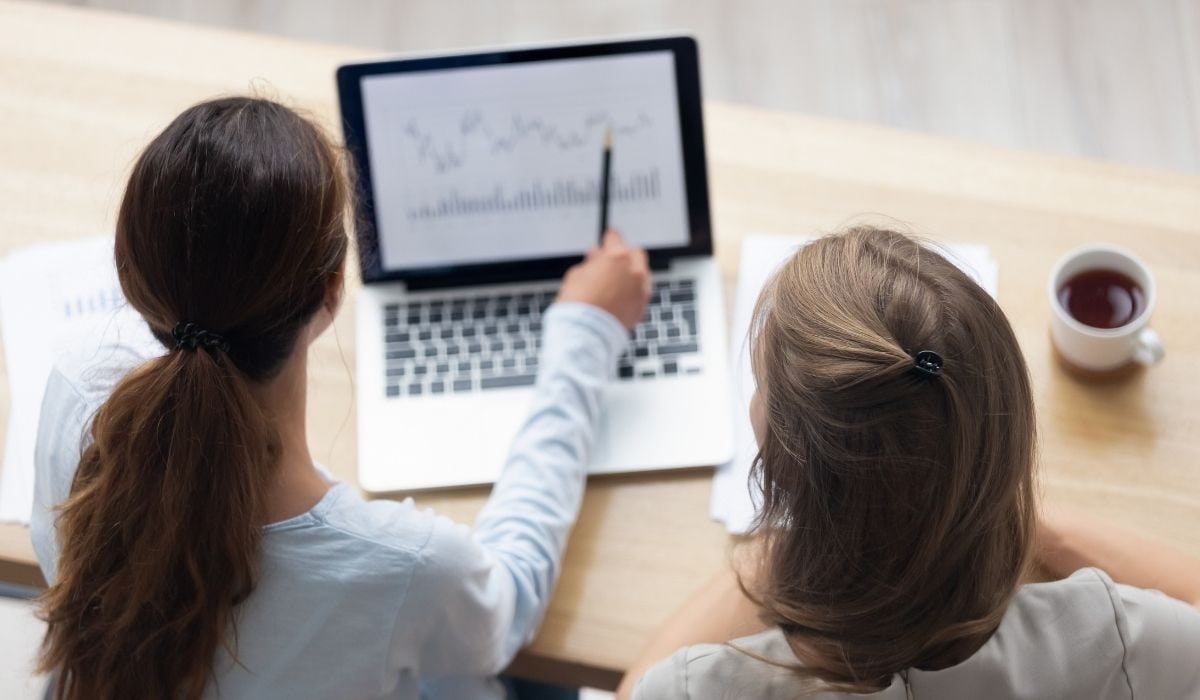 Two women looking at a graph on a laptop screen