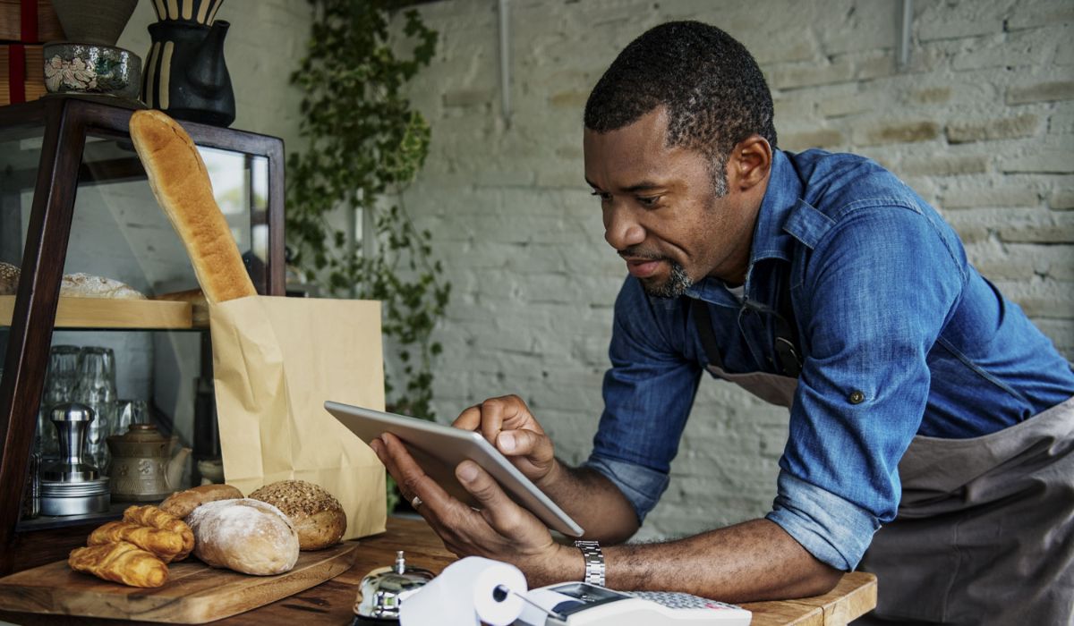 Male employee at a bakery checking a tablet